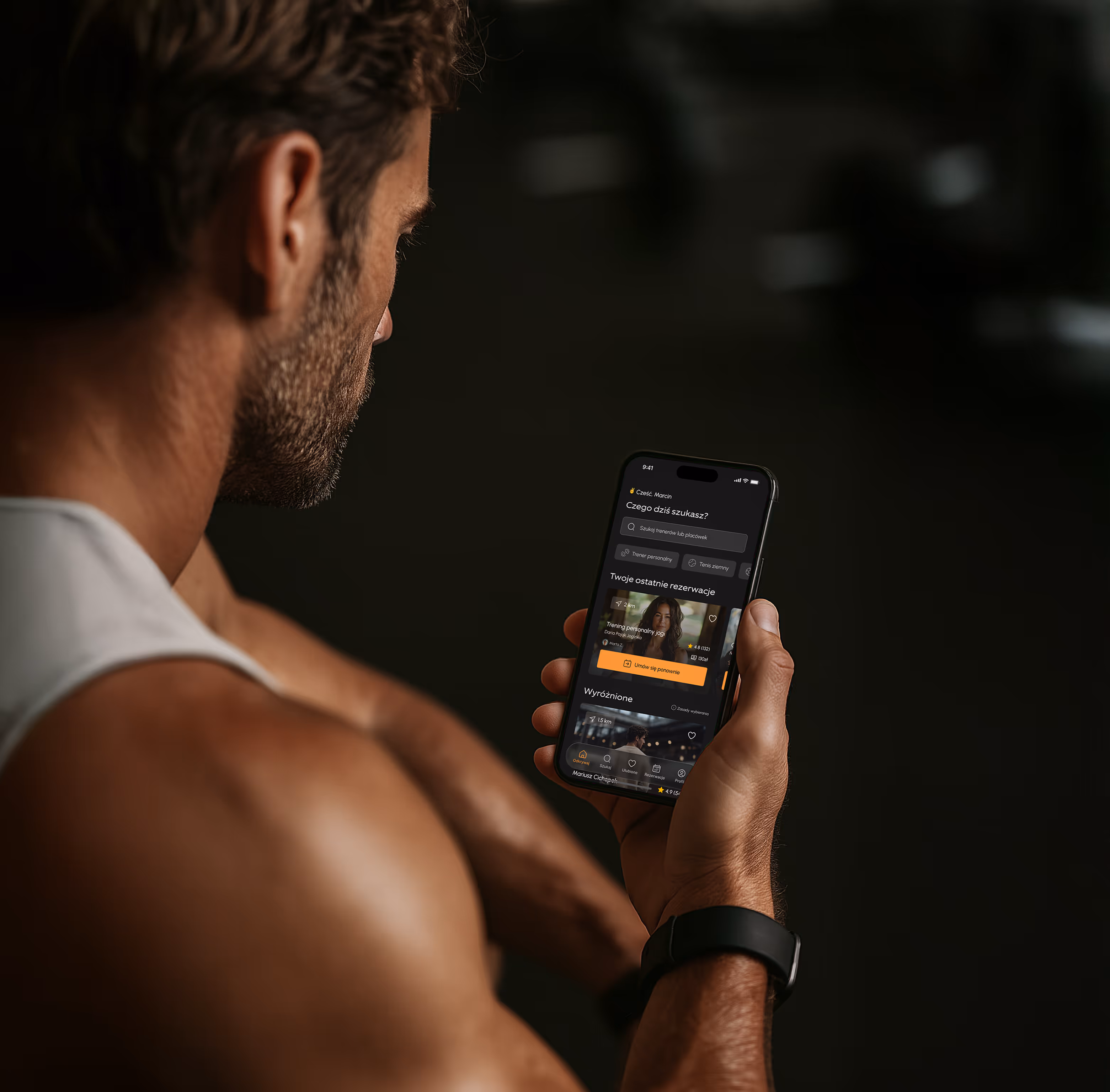 Trener trzymający telefon z aplikacją